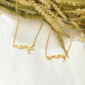 Dettaglio di collane dorate mama e amour con accenti in zircone su sfondo bianco puro - Stile Lettera Amour