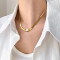 Dettaglio di una collana a catena a serpente dorata con un singolo zircone su una modella - Stile Catena a Serpente con Zircone Singolo