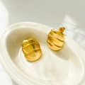 Macro detail of 18K gold plated titanium steel earrings with wavy textured surface - Quilted Pattern