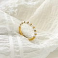 Détail d'une bague en perles d'eau douce avec billes dorées sur tissu texturé blanc - US 6 / Perle et perle ronde espacées