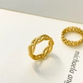 Details des goldgeflochtenen Rings und des hohlen geometrischen Bands auf weißem Grund - US 6 / Weben