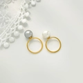 Détail de bagues en acier titane ornées de perles naturelles blanches et gris-violet - US 6 / Bague fermée à perle blanche