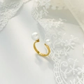Détail macro d'une bague ajustable en titane doré avec deux perles blanches élégantes - US 6 / Bague ouverte à grandes et petites perles