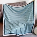 Detail of blue square silk scarf with interlocking chain pattern on leather surface - Sky Blue