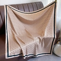Detailed macro view of champagne silk scarf with black chain ring pattern and wide borders - Khaki