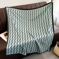 Detail of mint green square silk scarf with letter B monogram on leather sofa - 90*90cm / Light Blue