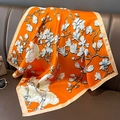 Detailaufnahme von orangefarbenem Seidenschal mit weißem Magnolienmuster und Satinkante - Orange (W-195-2)