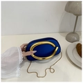 Dunkelblaue ovale Abendtasche mit goldenem Metallgriff und Kette auf weißem Tisch - Blau