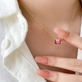 Détail d'un collier chaîne serpent dorée avec zircon rouge carré porté par un mannequin - Zircon Rouge Carré