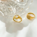 Detail van 18k vergulde titanium ringen met druppelvormige zirkoon en getextureerd metaal - US 6 / Peer Hart Zirkonia