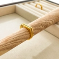 Vista dettagliata di un anello geometrico dorato con piccolo occhiello su legno - US 6 / Doppio Anello D Aperto / Oro