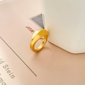 Dettaglio dell'anello doppia D in oro lucido appoggiato su ceramica bianca in stile lifestyle - US 6 / Arco Convesso / Oro