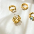 Dettaglio di anelli in titanio placcati oro con cristalli e zirconi blu assortiti - US 6 / Zircone a Goccia d'Acqua Triplo Strato Cavo