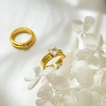 Dettaglio macro dell'anello dorato con zircone a cuore e design a catena intrecciata - US 6 / Zircone a Cuore