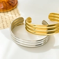 Detail van tweekleurige gevlochten titanium stalen armband met gelaagd ribbelontwerp - Drievoudige Boog (Goud)