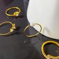 Dettaglio di un set di quattro anelli d'oro in titanio con perle, zirconi e opali - Stile perle d'acqua dolce