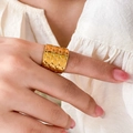 Detalle de un anillo ancho de acero chapado en oro con textura de hoyuelos en mano - US 6 / Estilo de Superficie con Puntos Redondos