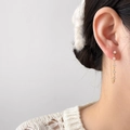 Détail de boucles d'oreilles pendantes dorées avec zircons fins et motifs floraux - Style de Zircon Blanc à Gland