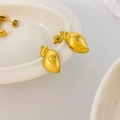Macro detail of wave edge C-shape shell earrings in polished 18K gold plated steel - Conch Style / Conch