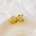 Detailed close-up of 18K gold-plated wavy twisted C-shaped stud earrings on a ceramic bowl - Double Cross Arc