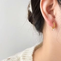 Close-up of elegant gold hoop earrings with pearl charms worn on a cozy sweater model - Freshwater Pearl (1.2cm/With Letter H)