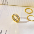 Dettaglio anello dorato con intarsio geometrico argento su pagine di un libro - US 6 / Bicolore Finto Tre Strati