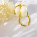Detail eines verstellbaren Goldperlenarmbands mit einem weißen Süßwasserperlenanhänger - Kleine goldene Perle Einzelne Süßwasserperle Armband