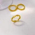 Vista dettagliata di tre anelli in acciaio al titanio placcati oro 18K con varie texture - US 6 / Stile Arco a Onda