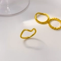 Detail showing 18K gold-plated titanium wave rings and geometric engraved band set - Pointed Curve Style