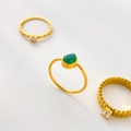 Detail shot of a minimalist gold ring with a pear-shaped green zircon and gear textures - US 6 / Green Zirconia Water Drop