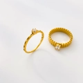 Detail of two gold plated titanium steel rings with clear zircon and ridged textures - US 6 / Mini Zircon