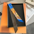 Dettaglio di un elegante foulard in seta con motivi a catena e cintura su un vassoio - Blu Reale