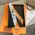 Detail van een smalle zijden twilly sjaal met cartoonmotieven in een oranje geschenkdoos - 5*85cm / Oranje (TLP-178-1)
