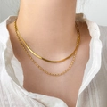 Double-layered gold snake chain and beaded necklace worn on a model in white shirt - Double Layer Snake Bone & Rice Bead Style / Gold