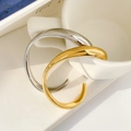 Polished gold and silver wave bangles displayed on minimalist ceramic background - Irregular Curved Open Cuff Gold