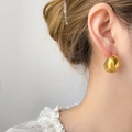 Macro shot of gold teardrop stud earrings with a polished mirror finish on model - Hollow Thick Moon / Gold