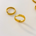 Dettaglio degli anelli in titanio placcato oro 18K con incisione a stella e fascia aperta - US 6 / Raggio