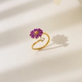 Detail of a golden open ring featuring a purple daisy flower and a sparkling zircon stone - US 6 / Rotatable Purple Flower