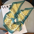 Detailed close-up of patterned silk scarf placed on a fashion magazine with pearl headband - Blue-Yellow
