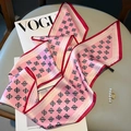 Detailed view of pink paisley silk scarf with red stitched edges and soft satin texture - Pink