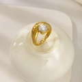 Macro view of 18K gold plated ring with a round zircon stone on a white ceramic stand - US 6 / Round Zirconia