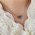 Detail of three multi-color round zircon stones on a 18K gold plated necklace chain - Tri-Color Zircon