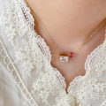 Close-up of 18K gold-plated necklace with rectangular white and round pink zircon stones - Square White Zirconia + Round Pink Zirconia