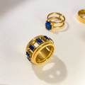 Macro detail van 18K vergulde ringen met blauwe zirkoon en gegraveerd sterpatroon - US 6 / Vierkante Blauwe Zirkoon Hol