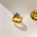 Macro-detail van de 18K vergulde brede ring met paarse en blauwe zirkonia steentjes - US 6 / Vierkant Oog Paars Blauw Zirkonia