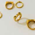Macro detail of gold-plated DAD ring featuring clear zircon stone and polished finish - US 6 / DAD Letter Style