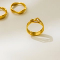 Primer plano de anillos de titanio bañados en oro de 18K con diseño de picos y olas - US 6 / Superposición Triangular de Capas Múltiples