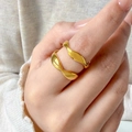 Primer plano de dos anillos ondulados chapados en oro de 18K en acero de titanio - US 6 / Onda Curvada (Arriba)