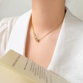 Dettaglio ravvicinato di una collana a goccia in oro 18K con zircone su una modella - Stile Goccia d'Acqua con Coulisse Regolabile