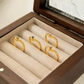 Set van vier golvende 18K vergulde stapelbare ringen met gekleurde zirkoon op houten display - US 6 / Puntige Rode Zirkonia